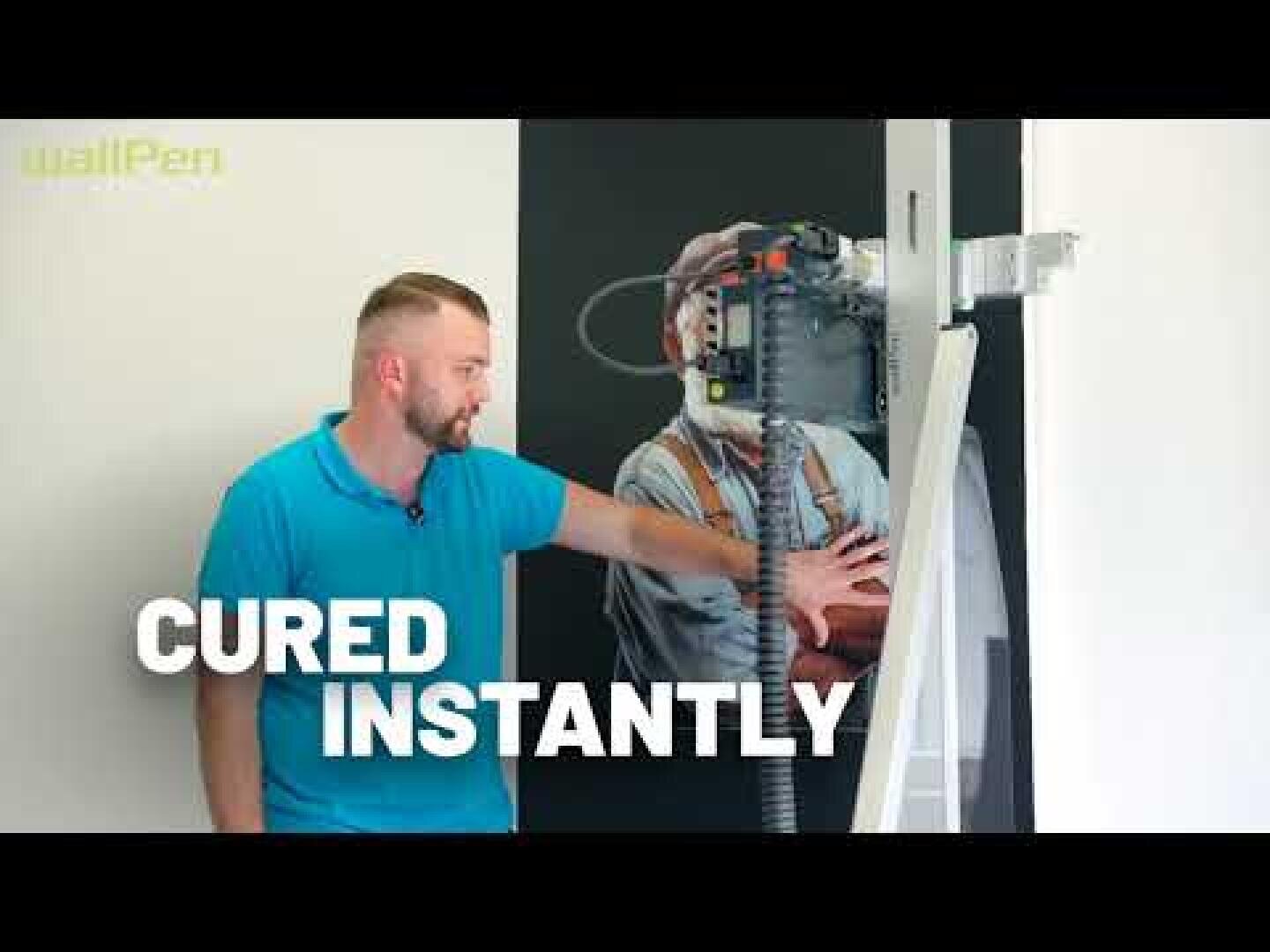 Ein Mann in einem blauen Hemd steht neben einem Wanddrucker und berührt ein gedrucktes Bild eines Arbeiters. Der Schriftzug "CURED INSTANTLY" steht in fetter weißer Schrift quer über dem Bild.